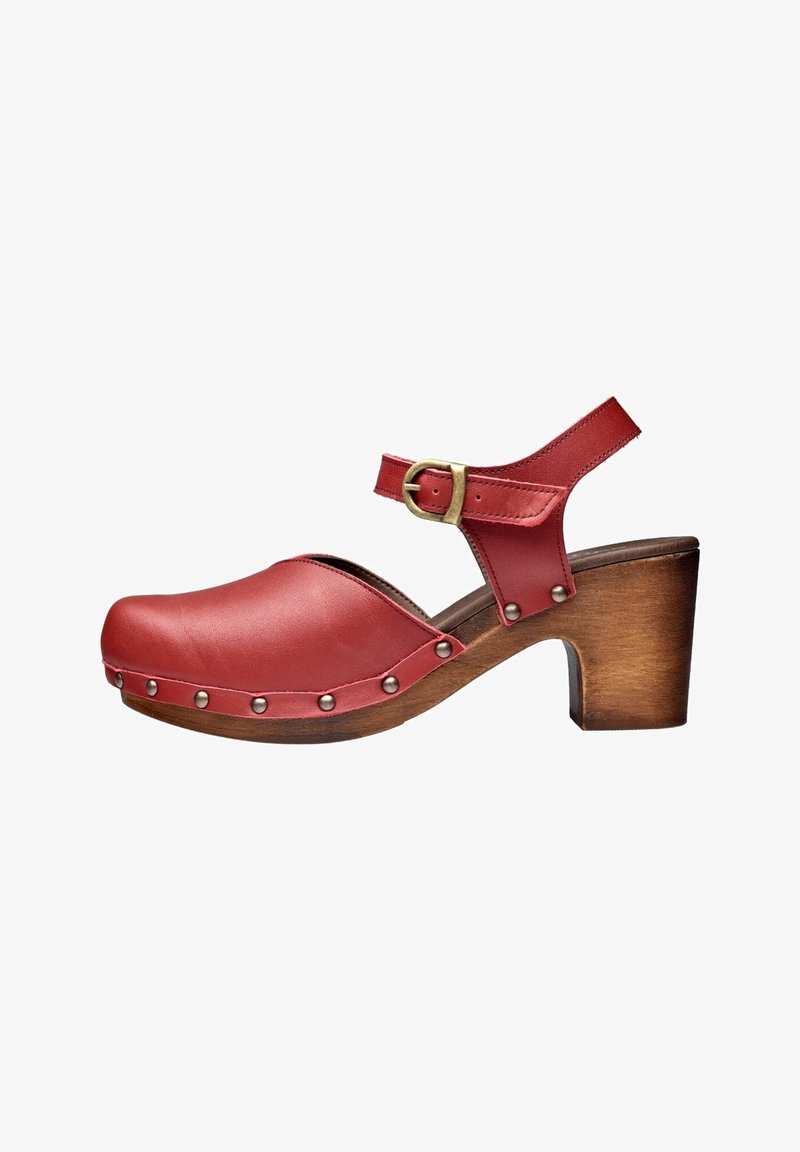 Chaussure style sabot en cuir rouge avec bride à la cheville, boucle en laiton, clous argentés et talon bloc en bois.
