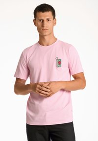 Ljusrosa bomullströja med korta ärmar, pryd med en ficka broderad med en grön juiceförpackning och röd hjärtformad design.