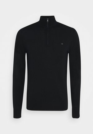 Černý pletený pulovr s dlouhými rukávy, límcem se čtvrtinovým zipem a malým logem "ck" na levé straně hrudi.