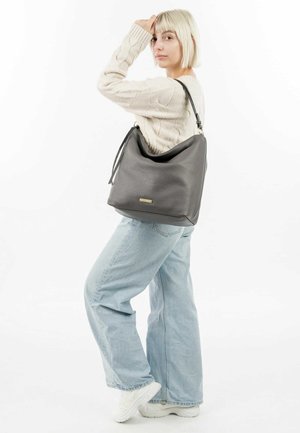 Grijze leren hobo-tas met een slappe vorm, textuur aan de oppervlakte, een verstelbare schouderband en een klein metalen logo-accent op de voorkant.