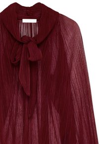 Burgunderfarbene, plissierte Bluse mit einem Schleifenkragen. Halbtransparentes Material, das eine gewellte Textur und vertikale Linien aufweist.