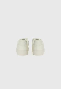 White leather sneakers with smooth texture, rounded design, low-top style, and matching rubber soles, showcasing stitched detailing.
