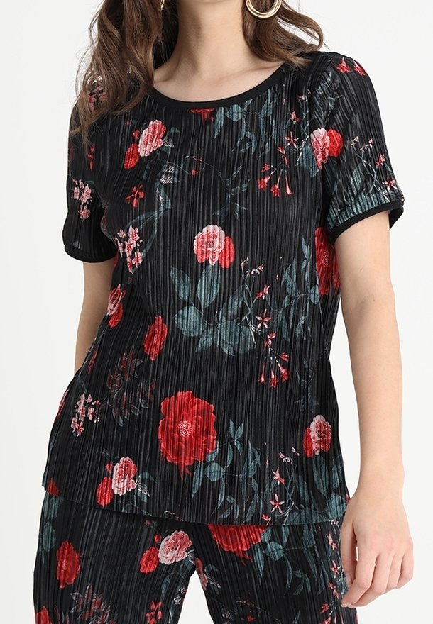 Haut noir à manches courtes plissé avec des motifs floraux rouges et teal, col rond et bordure contrastante, conçu pour un fit ample.