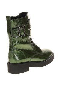 Groene gepatineerde leren enkelboots met een vetersluiting aan de voorkant, een zijgesp detail en een gestructureerde afwerking, met een stevige zwarte zool.