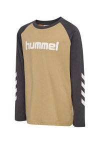 Långärmad skjorta med en tan kropp och mörkgrå raglanärmar. Har en stor vit "hummel"-logotyp och vita chevronränder på ärmarna.