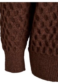 Bruine gebreide sweater met een gestructureerd oppervlak met verheven patronen, geribde manchetten en een zachter, wolachtig uiterlijk.