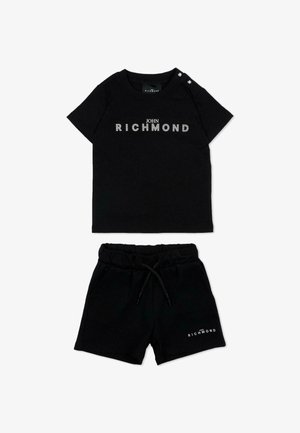 Zwarte peuteroutfit met een kortemouwenhemd en korte broek, beide met witte "John Richmond"-branding, het hemd heeft knopen op de schouder.