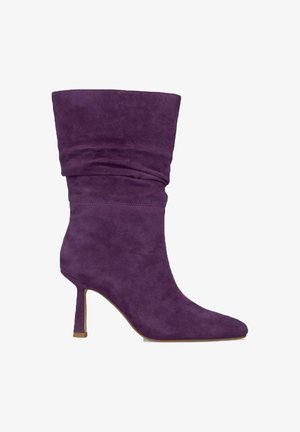 Botte de cheville en suede violet avec un design fluide, bout pointu et talon aiguille fin. Texture lisse et embellissements minimalistes.