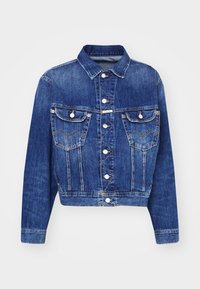 Denim jacket in dark blue with a collar, button front, and two chest pockets. Features visible stitching and a cropped design.