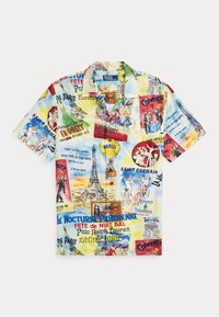 Camicia a maniche corte con bottoni su uno sfondo chiaro, caratterizzata da stampe colorate a tema Parigi, comprese illustrazioni e testi, principalmente in blu e rosso.