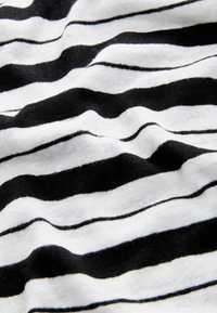 Black and white striped fabric with a soft texture, displaying alternating horizontal stripes of varying widths.