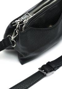 Borsa a mano in pelle nera con finitura texturizzata, chiusura con zip e hardware in tono argento. Presenta una tracolla regolabile e una piccola tasca esterna.
