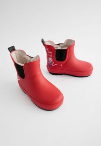 Rote Gummistiefel mit einem schwarzen elastischen Einsatz an der Seite und einem weichen, leichten Innenfutter. Auf einer Seite befindet sich ein grafisches Design und eine strukturierte Sohle.