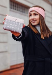 Růžová a šedá peněženka s květinovým a logovým vzorem, vyrobená z umělého materiálu, s zipovým uzavřením a sloty na karty.