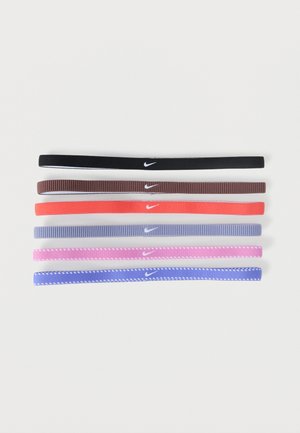 Six bandeaux en tissu Nike en noir, marron, corail, bleu clair, rose et bleu, chacun avec un petit logo swoosh blanc centré.
