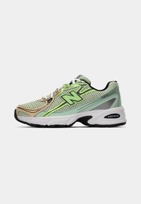 Sportieve schoenen in lichtgroen met beige accenten. Bovenwerk van gaas, rubberen zool, reflecterende elementen en het New Balance-logo. Ontworpen voor comfort en ondersteuning.