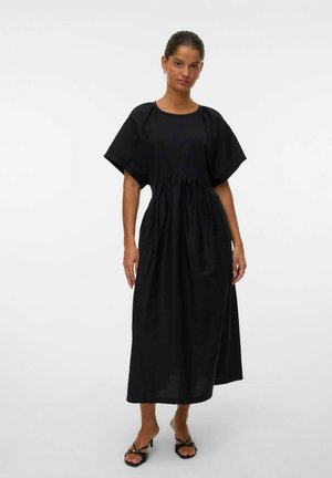 Robe en coton noir à coupe décontractée, à manches courtes, taille froncée et ourlet longueur cheville. Design simple sans motifs ni accents.