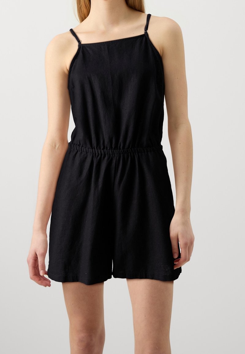 Mono negro sin mangas con escote cuadrado, cintura elástica y corte relajado. Fabricado con una tela suave y ligera de textura suave.