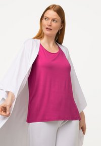 Fuchsia Tanktop mit lockerer Passform, kombiniert mit einem fließenden weißen Kimono. Glatte Textur, runder Ausschnitt und lässige Ärmel.