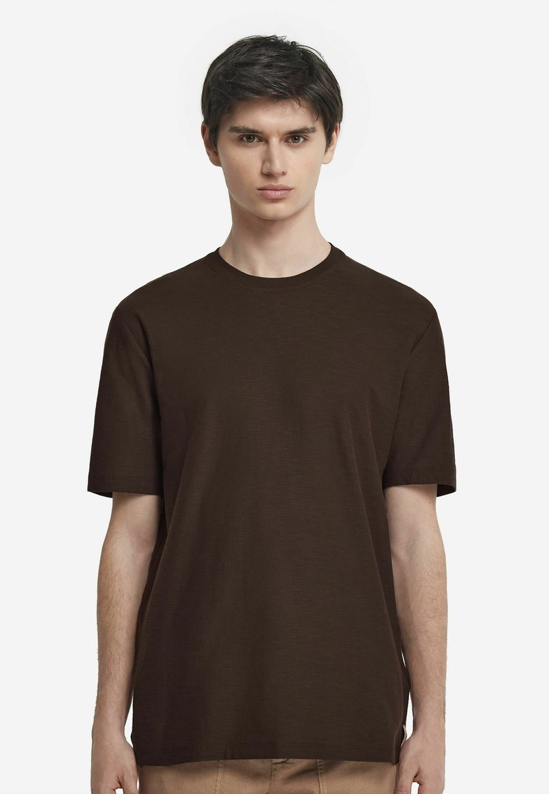 Braunes Kurzarm-T-Shirt aus weichem Stoff mit rundem Halsauschnitt und lockerer Passform, das eine glatte Textur und ein minimales Design aufweist.