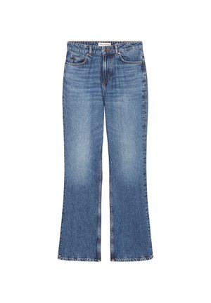 Personne portant une veste en jean bleu moyen avec manches retroussées et un jean droit taille haute assorti, associée à des talons ouverts noirs.