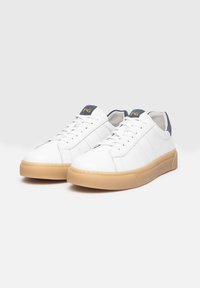 Weiße Leder-Sneaker mit glatter Oberfläche, runder Zehenpartie und Sohle aus Gummi. Ausgestattet mit navyfarbenen Akzenten an der Zunge und minimalistischem Design.
