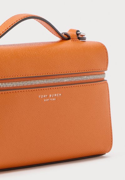 Πορτοκαλί δερμάτινη τσάντα χειρός με κορυφαία λαβή, ασημένιο φερμουάρ και ανάγλυφο λογότυπο "Tory Burch New York" στο μπροστινό μέρος.