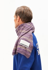 Paars en beige gestreepte sjaal van zacht breiwerk, met een opvallend wit label waarop "ARMEDANGELS" staat.