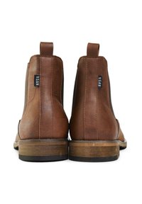 Brown vegan leather ankle boots with a textured finish, elastic side panels, and brown wooden heels. Includes small black brand tag.