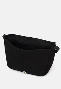 Černá textilní taška s hladkým povrchem, otevřeným vrchem a zlatým uzávěrem na knoflík. Má měkký, neformovaný tvar a jedno ramenní ucho.