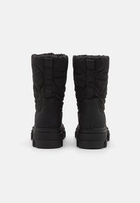 Schwarze, gesteppte Stiefel mit hohem Knöchel, ausgestattet mit einer strukturierten Außenseite, einer robusten Gummisohle und vertikalen Stoffschlaufen auf der Rückseite.