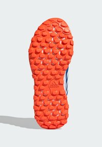 Podeszwa zewnętrzna zapewniająca przyczepność w żywym pomarańczowym kolorze, z sześciokątnymi wzorami i teksturowaną powierzchnią dla lepszej przyczepności. Zawiera wytłoczone logo.