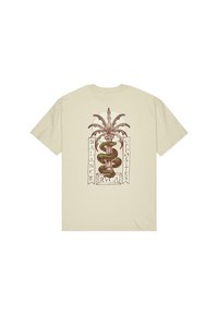 Camiseta de algodón beige con un diseño gráfico que presenta una serpiente enroscada alrededor de una columna, flanqueada por acentos de hojas y el texto "BALANCE OPPOSITES."