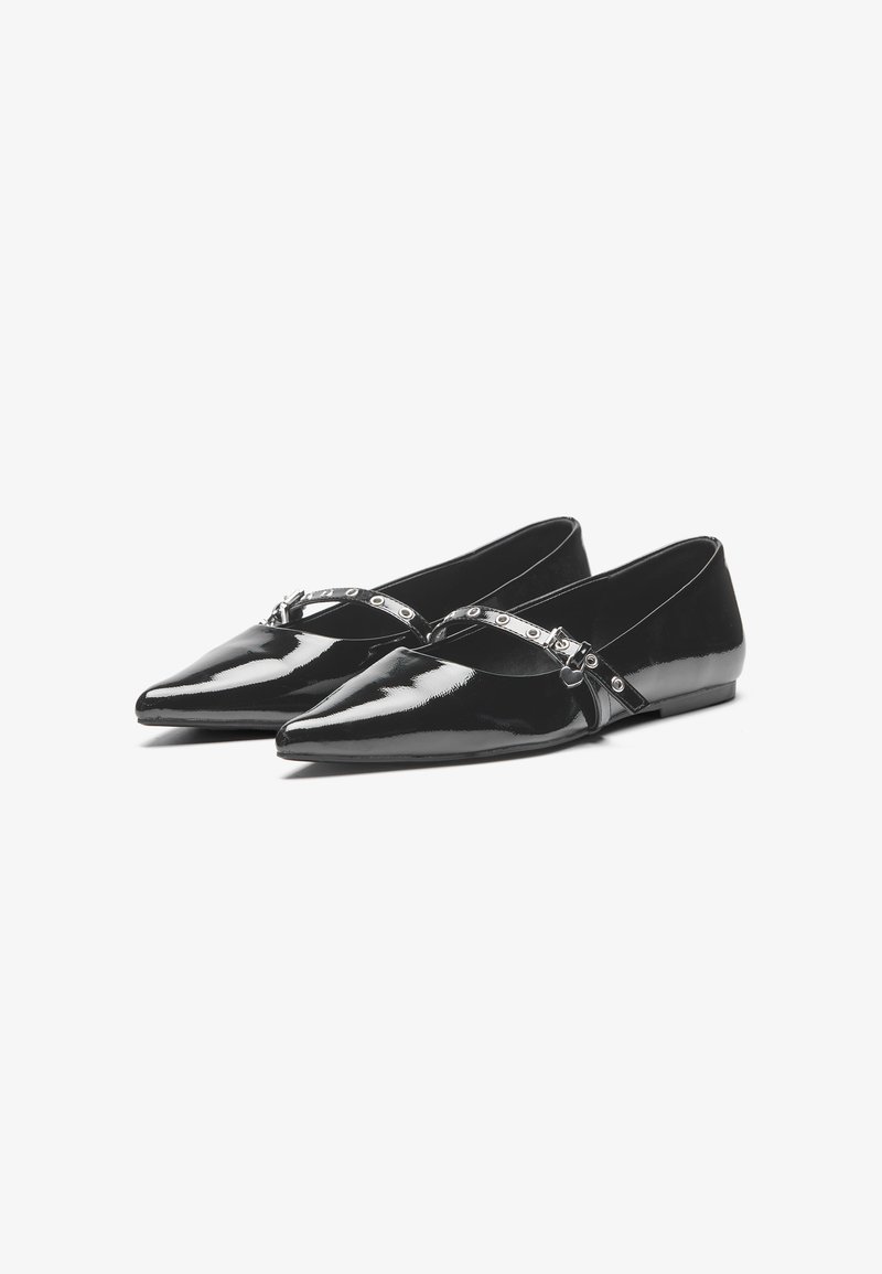 Chaussures plates en cuir verni noir avec des pointes effilées, présentant un détail de bande argentée et de petits accents ronds. Texture lisse et design élégant.