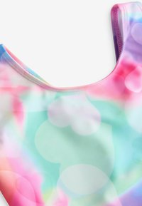 Sz�ínes fürdőruha, amely lágy, sima textúrával rendelkezik, és pink, kék és zöld árnyalatokból álló árnyékos mintázattal, valamint szívformájú mintákkal díszített.