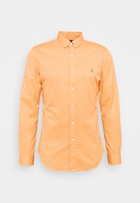 Košile s dlouhým rukávem v oranžové barvě ze 100% bavlny, s malým zeleným vyšívaným logem. Má klasický límec a manžety na knoflíky.
