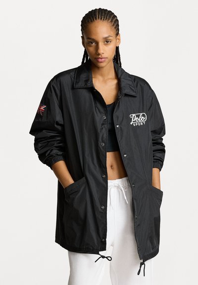 Schwarze, leichte, langärmelige Jacke mit Knopfverschluss, seitlichen Taschen und gesticktem Logo. Verfügt über elastische Bündchen und Saum.