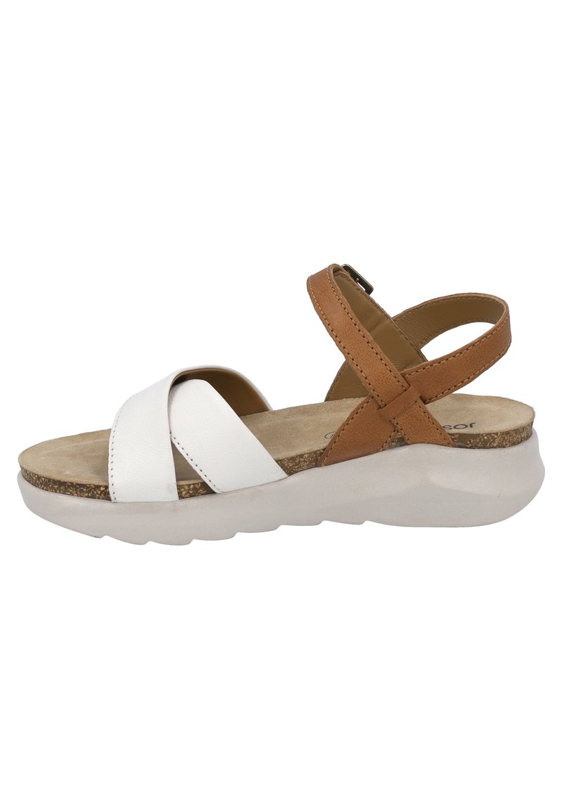 White and tan leather sandal with crisscross straps, cushioned insole, and a thick white outsole. Side view showcases adjustable buckle detail.