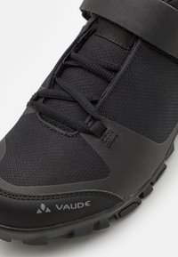 Schwarzer Radschuh mit strukturiertem Obermaterial, runder Zehenform, Schnürverschluss und einem Riemen über dem Mittelfuß; Gummisohle mit Rutschdetails.