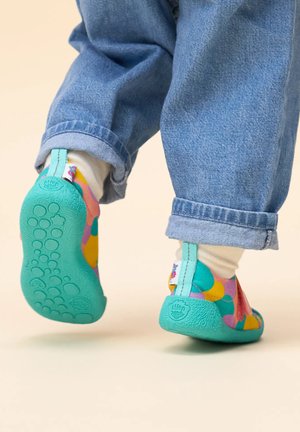Colorful children's shoes with a green sole, featuring a pattern of pink, blue, yellow, and orange dots. Designed for flexibility and comfort.