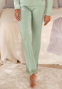 Helle grüne Lounge-Hosen mit einem taillierten Bund und ausladenden Beinen; detaillierte Spitzenverzierungen am Saum; glattes Material und bequemer Stoff.
