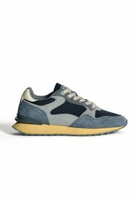 Baskets décontractées pour homme dans des nuances de bleu et de gris avec des lacets beiges et une semelle en caoutchouc jaune, présentées en profil gauche sur fond blanc.