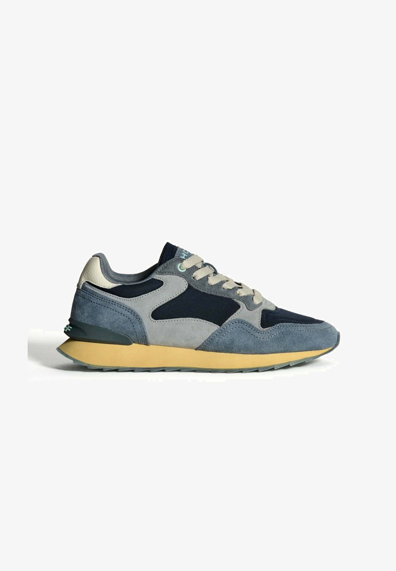 Baskets décontractées pour homme dans des nuances de bleu et de gris avec des lacets beiges et une semelle en caoutchouc jaune, présentées en profil gauche sur fond blanc.