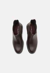 Stivaletti in pelle marrone con finitura liscia, pannelli laterali elasticizzati e un piccolo dettaglio del logo sul tallone. Suola in gomma piatta.