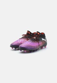 Black and purple football boots with a textured pattern, featuring red accents and a sock-like collar with traditional laces and molded studs.