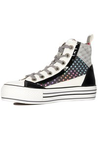 Hochschuh-Sneaker mit einem weißen und schwarzen Farbschema, ausgestattet mit einem Netzpaneel mit bunten Punkten und einer Gummisohle mit gestreiften Akzenten.