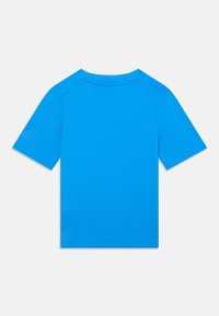Camiseta de manga corta en azul brillante, hecha de una suave mezcla de algodón, con cuello redondo y diseño de hombros sin costuras.