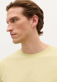 Lys gul crew-neck t-shirt lavet af bomuld. Har en diskret logo-brodering på brystet. Glat tekstur og korte ærmer.