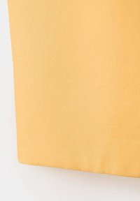 Tissu orange clair uni avec une texture lisse, présenté en gros plan avec une légère ombre près des bords.