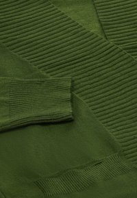 Maglione verde a maglia con texture a coste sulle maniche e sul colletto, corpo liscio e elementi di design sovrapposti.